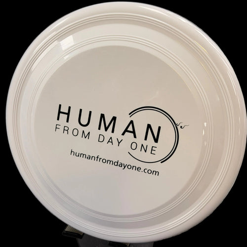 Round beige container with 'Human from Day One' branding on a gray surface